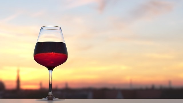 Glass of red wine on an outdoor counter at sunset
