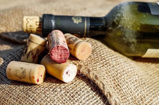 Corks lying in a pile next to a bottle of wine
